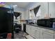 Kitchen featuring white cabinets, a black microwave, and a black refrigerator at 257 E Raleigh Blvd, Rocky Mount, NC 27801