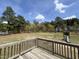 Lovely backyard showcasing mature trees, a green yard, and a classic wooden deck, perfect for relaxation at 27 Belmont Ct, Lillington, NC 27546