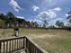 Expansive backyard with lush green grass, mature trees, and a charming playground area with slide and swings at 27 Belmont Ct, Lillington, NC 27546