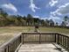 Expansive backyard view from the wooden deck overlooking the landscape and playset at 27 Belmont Ct, Lillington, NC 27546