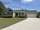 Charming one-story home with a well-manicured lawn and attached garage on a sunny day at 27 Belmont Ct, Lillington, NC 27546