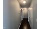 Long hallway featuring hardwood floors and white doors at 27 Belmont Ct, Lillington, NC 27546