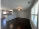 Open concept living room with hardwood floors, ceiling fan, and kitchen view at 27 Belmont Ct, Lillington, NC 27546
