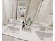 Well-lit bathroom features a dual sink vanity, decorative accents, and a view into another room at 817 Central Pk Dr, Raleigh, NC 27604