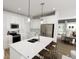 Bright kitchen features white cabinetry, stainless steel appliances, an island with seating, and pendant lighting at 817 Central Pk Dr, Raleigh, NC 27604
