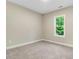 This bedroom features a window providing natural light and neutral carpeting at 303 Cherrybirch Ln, Zebulon, NC 27597