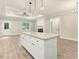 Bright, open-concept kitchen featuring a large island with granite countertops and modern lighting fixtures at 303 Cherrybirch Ln, Zebulon, NC 27597