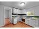 Kitchen featuring wood floors, white cabinets, and view into the next room at 312 E Highland Ave, Rocky Mount, NC 27801