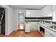 Bright kitchen featuring white cabinets, stainless steel sink, and wood flooring with a view into the living room at 312 E Highland Ave, Rocky Mount, NC 27801