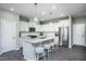 Bright kitchen featuring white cabinetry, stainless steel appliances, a large island, and a stylish breakfast bar at 355 Fosterton Cottage Way, Raleigh, NC 27603