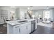 Open-concept kitchen with a large island, stainless steel dishwasher, and view into the dining and living areas at 355 Fosterton Cottage Way, Raleigh, NC 27603