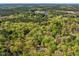 Expansive aerial view featuring a home surrounded by dense woodland and a small lake, blending nature and privacy at 363 Dublin Dr, Sanford, NC 27330