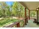 Covered porch with railing overlooking a serene backyard and tranquil pond at 363 Dublin Dr, Sanford, NC 27330