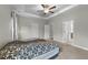 Large bedroom featuring tray ceiling, ceiling fan, neutral carpet, and adjoining bathroom with double sinks at 396 Martins Mill Ct, Wendell, NC 27591