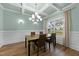 Bright dining room features elegant wainscoting, coffered ceiling, hardwood floors, and modern chandelier at 396 Martins Mill Ct, Wendell, NC 27591