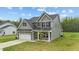 Charming two-story home with a well-manicured lawn, attached garage, and classic architectural details at 396 Martins Mill Ct, Wendell, NC 27591