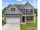 Charming two-story home with a gray exterior, a two-car garage, and a well-manicured lawn at 396 Martins Mill Ct, Wendell, NC 27591