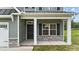 Charming home's front porch featuring stone accents, sturdy columns, and a welcoming black front door at 396 Martins Mill Ct, Wendell, NC 27591