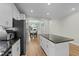 Bright kitchen featuring white cabinets, stainless steel appliances, granite countertops and dining area access at 396 Martins Mill Ct, Wendell, NC 27591