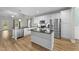 Spacious kitchen boasting white cabinets, stainless steel appliances, and a large island with granite countertops at 396 Martins Mill Ct, Wendell, NC 27591