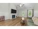 Cozy living room with a fireplace, vaulted ceiling, and access to the backyard at 396 Martins Mill Ct, Wendell, NC 27591