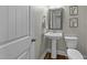Charming powder room with pedestal sink, framed mirror, wood-look flooring, and floral wall art at 396 Martins Mill Ct, Wendell, NC 27591