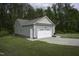 View of a detached two-car garage featuring gray siding, a white garage door, and a well-manicured lawn at 40 Patricia S Vann Ct, Dunn, NC 28334
