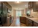 Eat-in kitchen with dark wood cabinets, laminate counters and black appliances at 40 Patricia S Vann Ct, Dunn, NC 28334