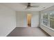 This bedroom boasts neutral carpet, a ceiling fan, a walk-in closet, and a large window at 400 Collington Dr, Mebane, NC 27302