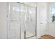 Walk-in shower with glass door and white marble tile walls. Fixtures show stainless steel at 420 Shelby Meadow Ln, Angier, NC 27501