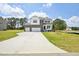 Inviting two-story home featuring stone and white siding, a three-car garage, and a long driveway at 420 Shelby Meadow Ln, Angier, NC 27501