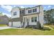 Charming two-story home showcasing stone and white siding, a covered front porch, and a lush green lawn at 420 Shelby Meadow Ln, Angier, NC 27501