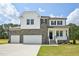 Beautiful two-story home featuring stone and white siding, a three-car garage, and a well-manicured front yard at 420 Shelby Meadow Ln, Angier, NC 27501