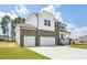 Elegant two-story home with stone and white siding, a three-car garage, and a spacious driveway at 420 Shelby Meadow Ln, Angier, NC 27501