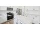 Spacious kitchen featuring white cabinets, stainless steel appliances, a center island, and bright lighting at 420 Shelby Meadow Ln, Angier, NC 27501