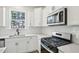 Modern kitchen features white cabinets, stainless steel appliances, quartz countertops and lots of natural light at 420 Shelby Meadow Ln, Angier, NC 27501