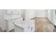 An open kitchen with quartz countertops, white cabinets, stainless steel appliances, and light wood flooring at 420 Shelby Meadow Ln, Angier, NC 27501