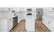 Well-lit kitchen showcasing white cabinets, stainless steel appliances, a kitchen island and light hardwood floors at 420 Shelby Meadow Ln, Angier, NC 27501