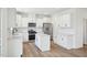 Spacious kitchen with quartz counters, island, stainless appliances, white cabinets, and light wood floors at 420 Shelby Meadow Ln, Angier, NC 27501