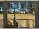View from the screened porch, with white railing and houses across the field at 420 Shelby Meadow Ln, Angier, NC 27501