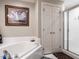 Bright bathroom showcasing a soaking tub, tiled walls, and glass enclosed shower at 4203 Norman Ridge Ln, Raleigh, NC 27613