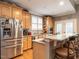 Well-lit kitchen with stainless steel appliances, light wood cabinets, and a marble countertop breakfast bar at 4203 Norman Ridge Ln, Raleigh, NC 27613