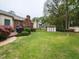 Expansive backyard with lush green lawn, mature trees, deck, grill, and storage shed at 422 Old Scarborough Ln, Garner, NC 27529