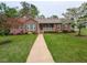 Charming brick home featuring a manicured lawn, inviting front porch, and beautiful landscaping at 422 Old Scarborough Ln, Garner, NC 27529
