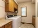 Laundry room with washer, dryer, cabinets, and a window at 422 Old Scarborough Ln, Garner, NC 27529