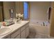 Bathroom featuring a large soaking tub and dual sinks with neutral color palette at 4610 Miller Dr, Durham, NC 27704