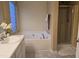 Bathroom featuring a large soaking tub and separate shower with neutral color palette at 4610 Miller Dr, Durham, NC 27704