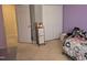 Cozy bedroom features lavender walls, storage unit, and neutral carpet at 4610 Miller Dr, Durham, NC 27704
