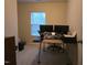 Bedroom featuring desk, two monitors, with neutral carpet and a window for natural light at 4610 Miller Dr, Durham, NC 27704