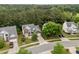 An aerial view shows the property has a brick and siding facade, a lush lawn, and mature trees at 4709 Knights Arm Dr, Durham, NC 27707
